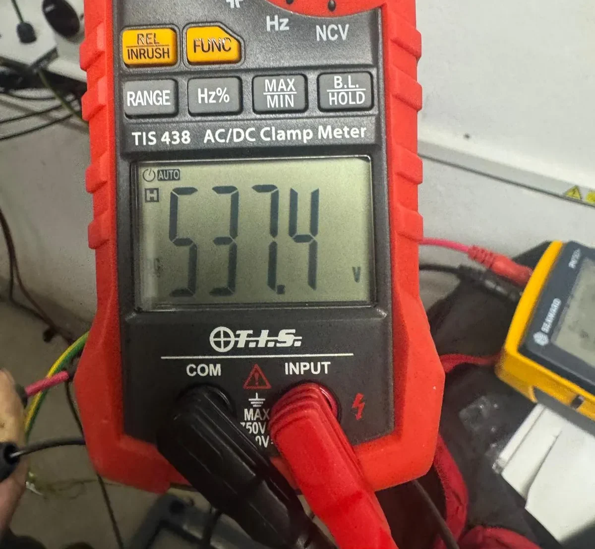 Electrician testing a circuit with a clamp meter